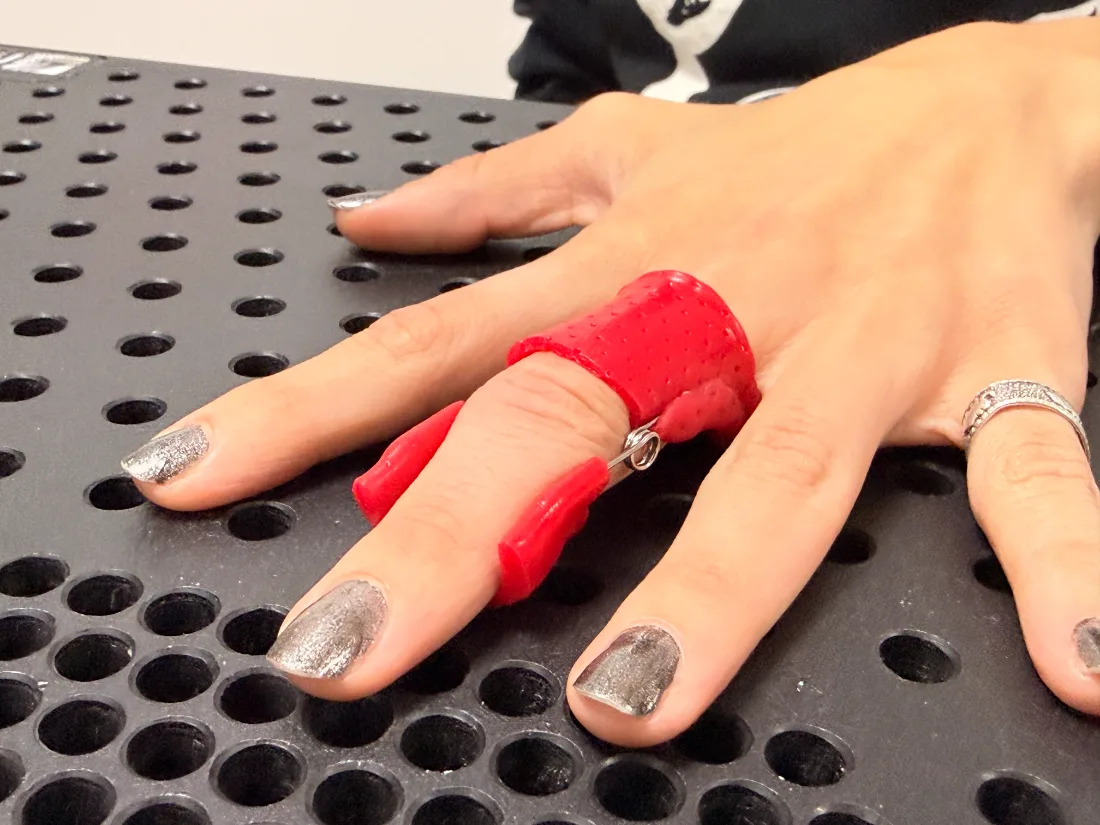 Órtesis termoplástica roja para dedo con resorte de extensión fabricada en RehabiliTO